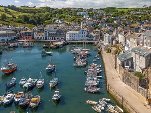 A harbor with numerous boats docked, surrounded by a town with historic buildings. - Piskey Cottage by Interhome (Mevagissey)