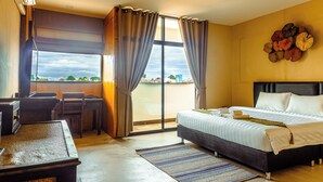 A hotel room with a bed, a desk, and a view of the outside. - EAIN (Chiang Mai)