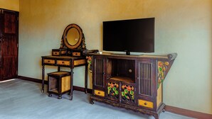 A room with a wooden cabinet, a television, and a mirror. - EAIN (Chiang Mai)