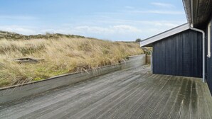 A wooden deck leading to a building with a dark exterior.