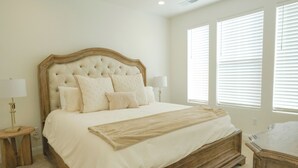 A bedroom with a large bed, two bedside tables, and a nightstand.
