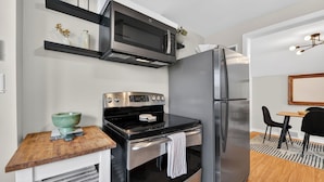 Una cocina compacta con microondas, horno y refrigerador.