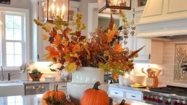 A kitchen with a marble countertop, a central island with a decorative arrangement of pumpkins and foliage, and hanging lantern-style lights. - Charming 4-bedroom house with WiFi, AC in Kingwood,TX (Humble)