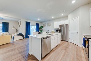 A modern apartment with a kitchen, living area, and a dining space. - New Spacious 4-bedroom house in charming Ankeny with WiFi, AC-Prime Location (Ankeny)