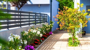 A garden pathway with various flowering plants and a wooden fence. - 6 bedroom amazing home in Bilice (Bilice)