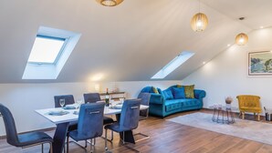 A modern loft apartment with a dining area, a blue sofa, and a yellow armchair. - 6 bedroom amazing home in Bilice (Bilice)