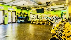 A gym with exercise equipment, a television, and a clock on the wall. - Large 3 Bedroom in Central Scottsdale w/ Pool, Clubhouse, Fitness Room and More… (Scottsdale)