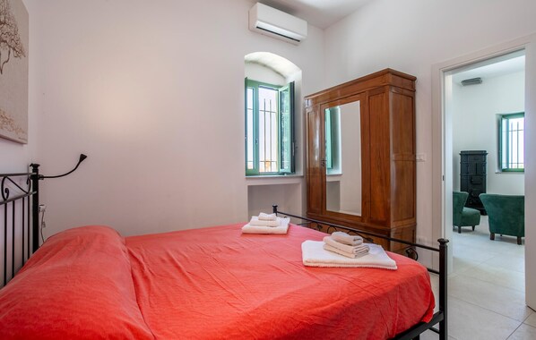 A bedroom with a bed, a wooden wardrobe, and a window. - Pet friendly home in Ragusa (Ragusa)