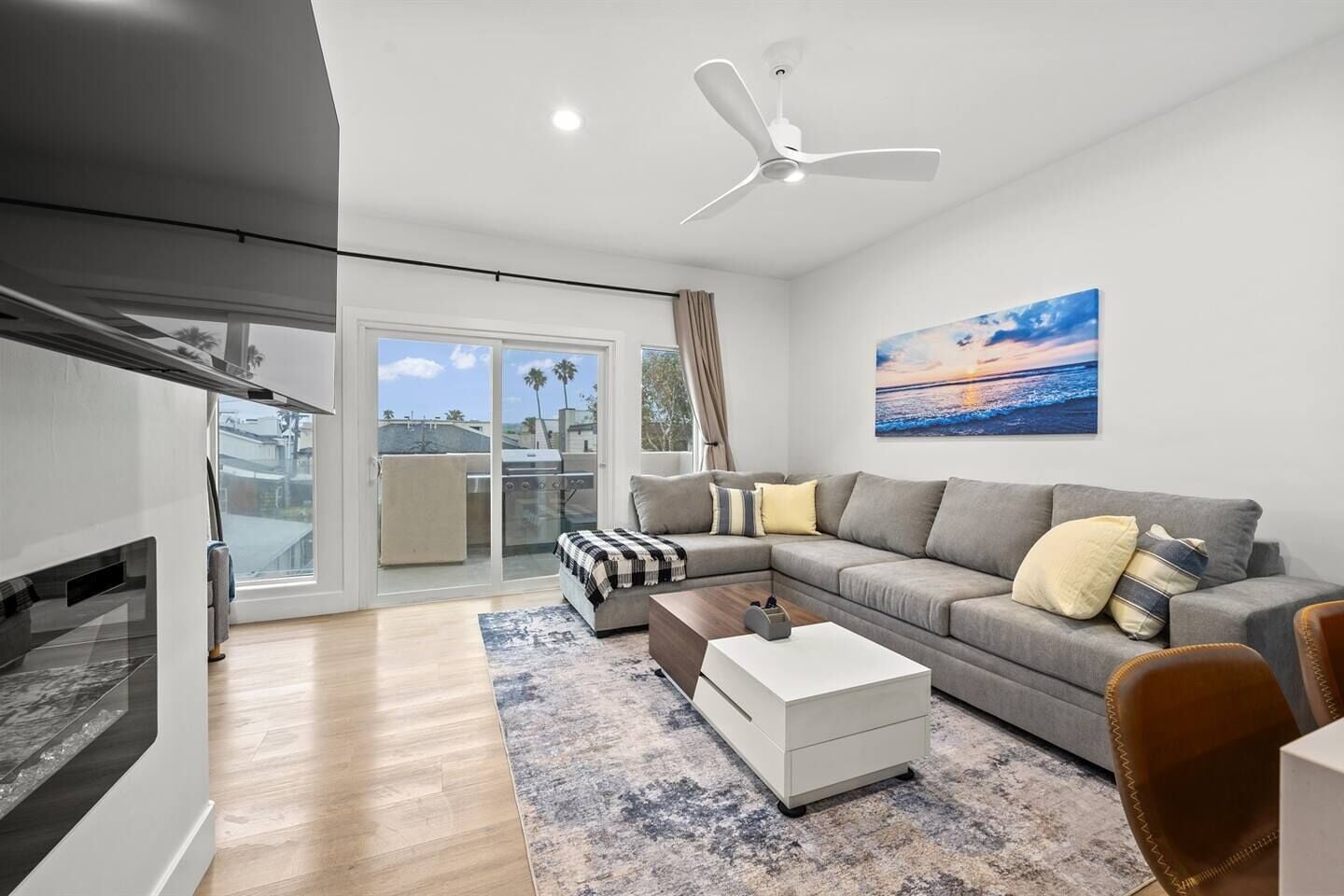 A modern living room with a grey sofa, a coffee table, and a fireplace.