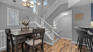 Une cuisine moderne avec un coin repas, un escalier et un bar.