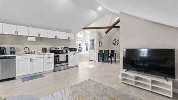 An open-concept living space that combines the kitchen, dining, and living room, all bathed in an abundance of natural light.