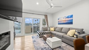 Ein modernes Wohnzimmer mit einem grauen Sofa, einem Couchtisch und einem Kamin.