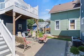 A backyard with outdoor furniture, a fire pit, and a covered patio area.