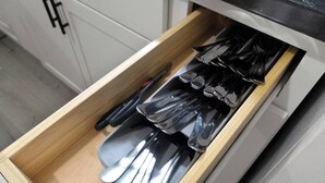 A drawer with utensils including spoons and a knife.