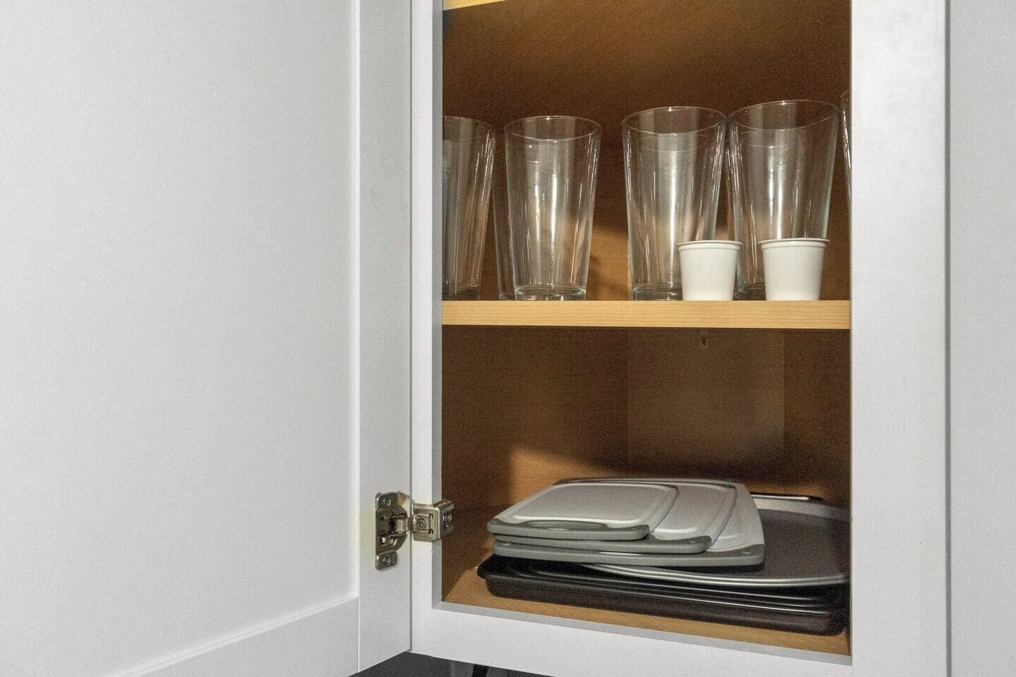 A cabinet with clear glassware and plates.
