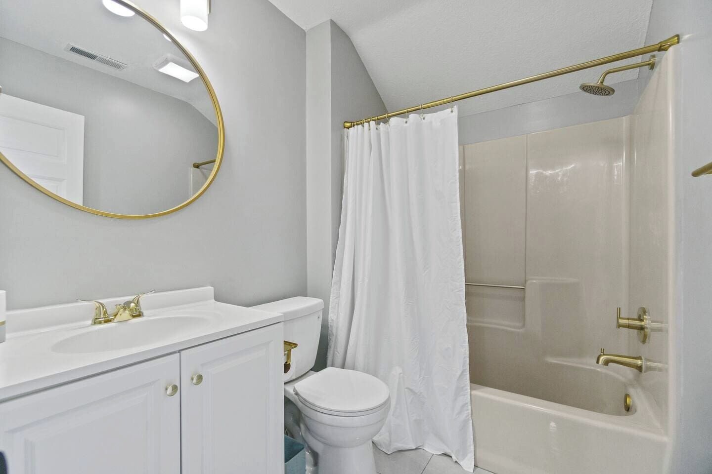 A bathroom with a white sink, toilet, and shower.