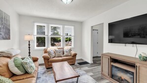 A living room with a sofa, coffee table, and TV stand.