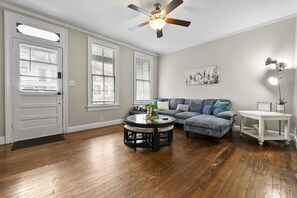 Un salon avec un canapé, une table basse et un ventilateur de plafond.
