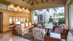 Un vestíbulo con zona de estar, mostrador de recepción y ventanas amplias con vistas al exterior.