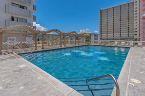 A swimming pool with a wooden pergola and a lifeguard station. - Newly Renovated Pink Paradise Studio (Honolulu)