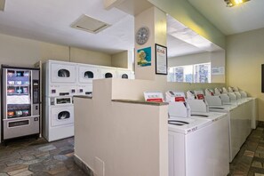 A laundry facility with multiple washing machines and a self-service laundry machine. - Newly Renovated Pink Paradise Studio (Honolulu)