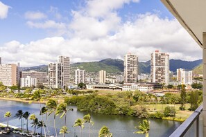 Un paisaje urbano con rascacielos, un río y palmeras.