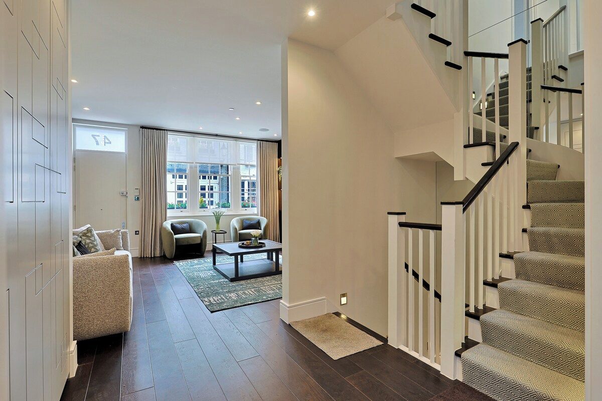 Un intérieur moderne avec un escalier, un canapé et une table basse.