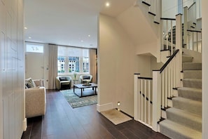 Un intérieur moderne avec un escalier, un canapé et une table basse.