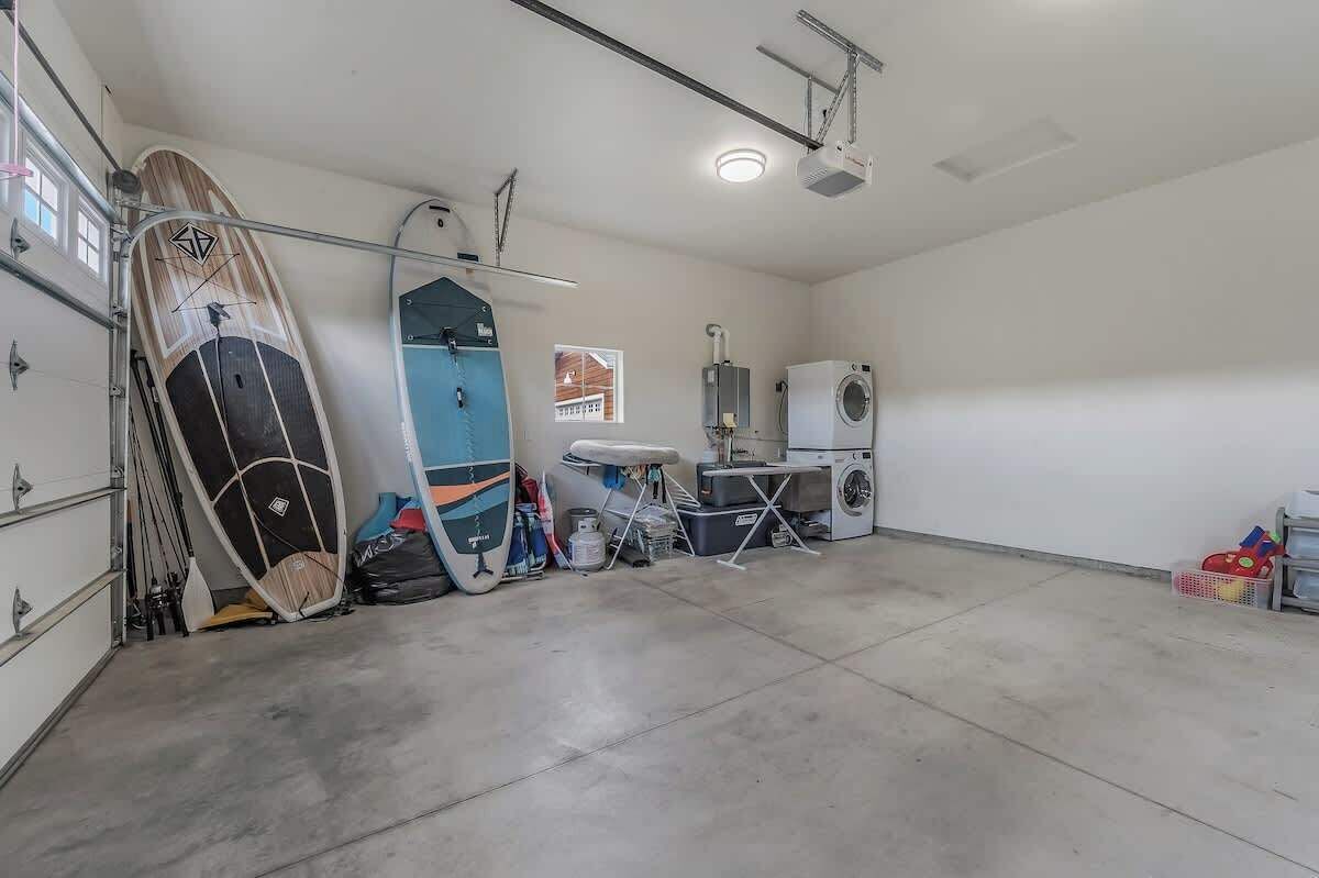 A garage with surfboards, a washing machine, and a ceiling-mounted projector.