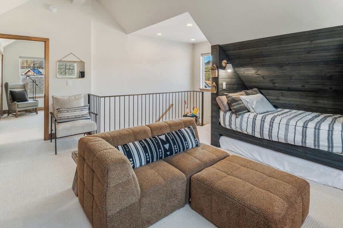 A cozy bedroom with a large bed, a sofa, and a chair.