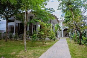A modern building with a covered walkway leading to a staircase. - Stone Age Boutique  (Kampot)