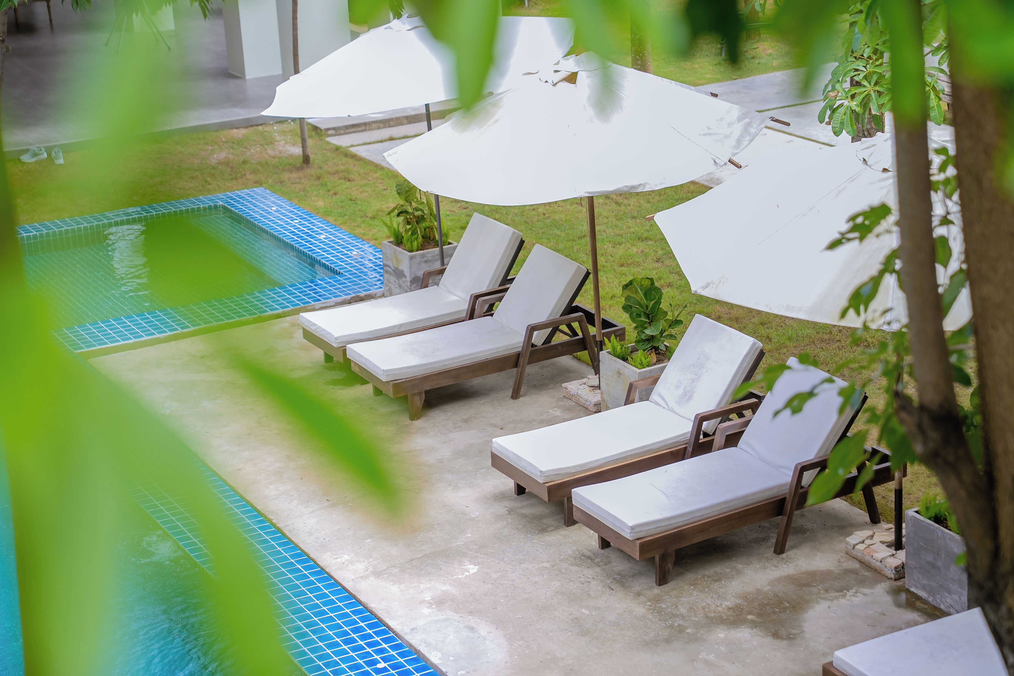 A poolside area with lounge chairs and umbrellas.