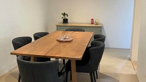 A modern dining area with a wooden table and six chairs, a small plant, and a globe on a shelf. - Gorgeous Griffith 2Bed/1Bath Pad (Griffith)