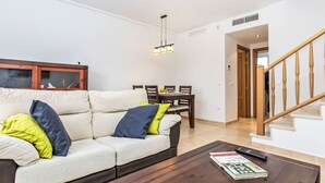 A living room with a sofa, coffee table, and dining area. - Llevant by Interhome (Creixell)