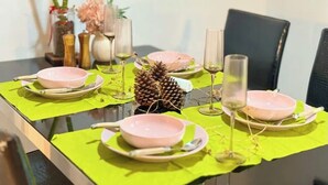 A dining table set with pink bowls, wine glasses, and a pineapple centerpiece.