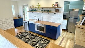 Cozinha moderna com ilha central, forno embutido e eletrodomésticos de aço inoxidável.