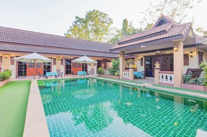 Una piscina al aire libre, sombrillas