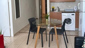 Un espacio habitable pequeño con comedor, cocina y una entrada acogedora.
