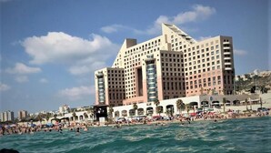 Un gran hotel con varios pisos y balcones con vistas a la playa.