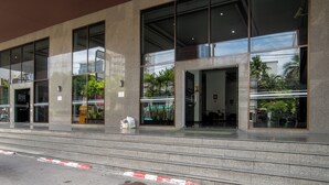 Un bâtiment moderne doté de grandes fenêtres et d’une façade en béton.