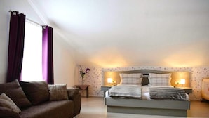 A bedroom with a bed, a sofa, and two bedside lamps. - Apartment Near Kurpark Lake (Bodenmais)
