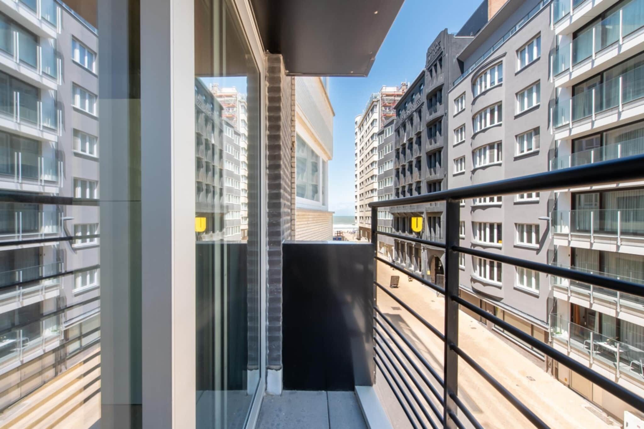 Ein modernes Apartment im Stadtzentrum mit einem Balkon mit Blick auf eine Straße.