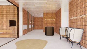 A modern interior with wooden panel walls, a reception desk, and a seating area with rattan chairs.
