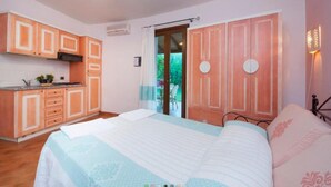 Une chambre à coucher avec un lit, une table de chevet et une fenêtre avec des rideaux.