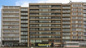 Un immeuble à plusieurs étages doté de balcons et d’un grand panneau publicitaire faisant la promotion de Dingo.