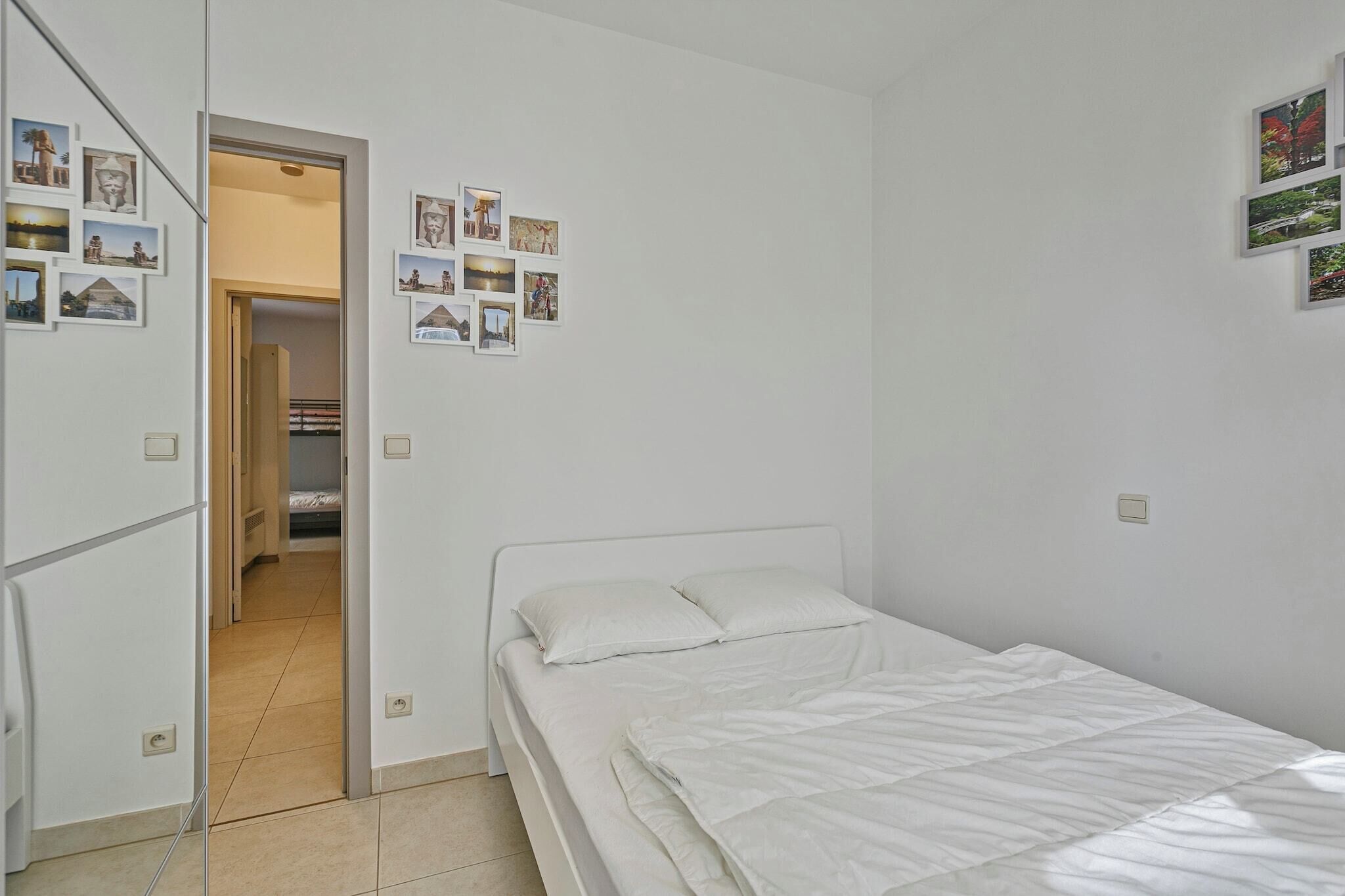 A bedroom with a bed, a wardrobe, and a door leading to a bathroom.