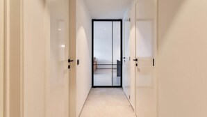 A modern hallway with a glass door leading to a balcony.