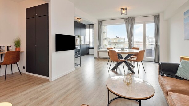 Een modern appartement met een eetgedeelte, een woongedeelte en een keuken.