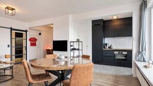 Een moderne keuken met donkere kastjes, een ingebouwde oven en een aanrecht.
