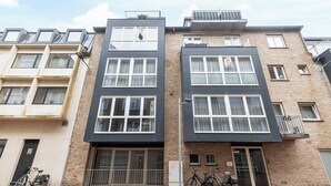 A modern apartment building with a flat facade, large windows, and balconies. - Apartment in Blankenberge near the Beach (BLANKENBERGE)